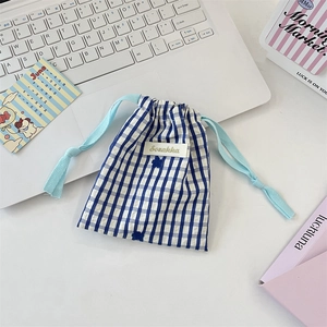Détail de la pochette de rangement en tissu à carreaux bleus et blancs avec cordon