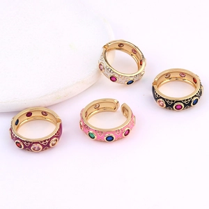 Detail of four colorful enamel rings with zircon inlays and vintage hollow texture