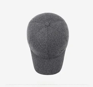 Top view showing fine knit texture and small metal logo on the dark grey winter cap