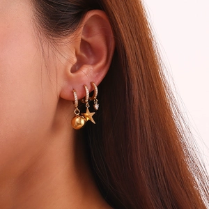 Set of three 18K gold plated stainless steel star heart and ball hoop earrings on ear