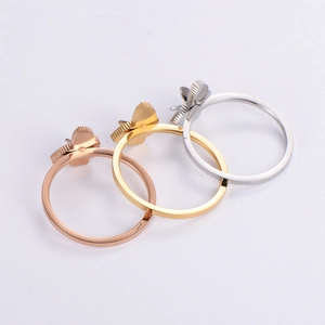 Three minimalist butterfly rings in gold, silver, and rose gold finishes on white background