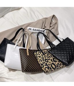 Selection of chic tote bags in crocodile, leopard, and quilted textures on elegant bedding