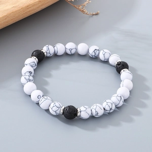 Macro shot of 8mm natural lava rock beads and white marble stones on an elastic bracelet