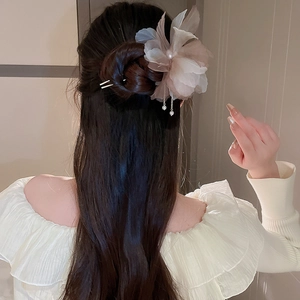 Détail d'épingle à cheveux fleurie avec pétales en organza, perles et glands pendants