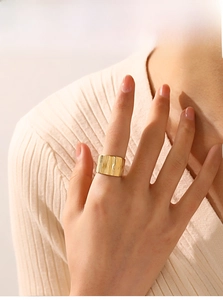 Detailed view of wide 18K gold plated stainless steel ring with vertical brushed texture