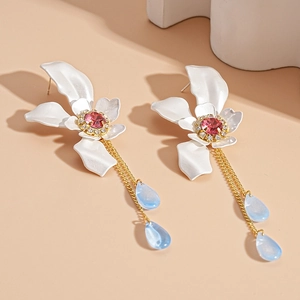 Detail of flower earrings with pink crystal center and blue teardrop crystal charms