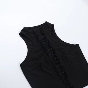 Detailopname van het gekruiste veterontwerp op deze zwarte mouwloze crop top