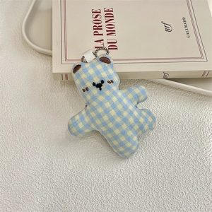 Macro shot of blue and yellow checkered plush bear keychain with metal bead chain detail