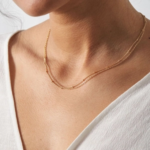 Close-up of double-layered gold stainless steel necklace with delicate bead details