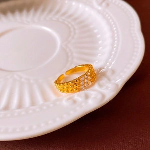 Détail d'une bague perlée plaquée or 18 carats avec des pierres de zircone étincelantes