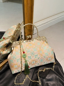 Vintage embroidered kiss-lock handbag with floral patterns and jade tassel on chain strap