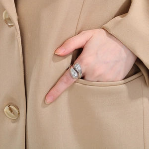 Detail of silver crossover stainless steel ring with star-shaped crystals on model hand