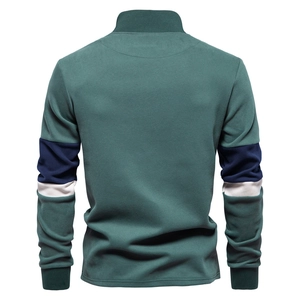 Detail of color-block sleeves with navy and white stripes on dark green polo sweatshirt