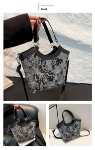 Detail of luxury black tote bag with white floral embroidery and leather trim handles