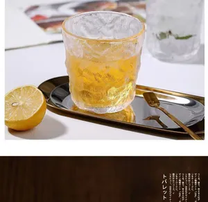 Close-up of heat-resistant glacier textured glass cup with gold tray and lemon garnish