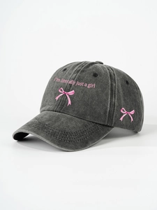 Detailed close-up of dark grey washed denim baseball cap with pink embroidery detail