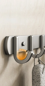 Detail of dark grey wall-mounted adhesive hooks with stable Golden R-angle design