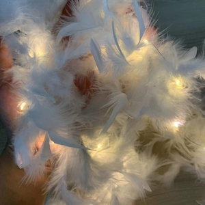 Detail of soft white feathers with warm yellow LED lights for festive Christmas decor