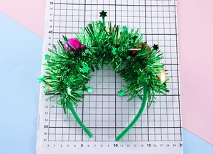 Detail of Christmas headband with sparkly green tinsel and colorful sequined ornaments