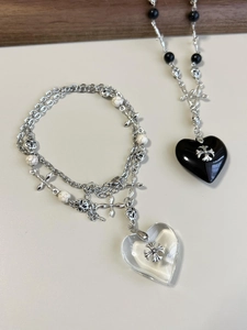 Detail of beaded necklaces with heart and cross pendants in industrial gothic style