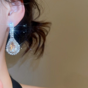 Close-up of elegant teardrop pear-shaped cubic zirconia earrings on model
