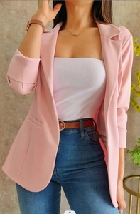 Detalle de chaqueta blazer rosa de manga larga con cinturón de cuero y vaqueros
