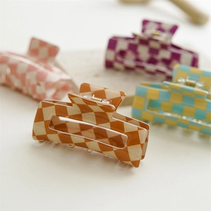 Close-up of square checkered hair claws in brown, pink, purple, and blue colors
