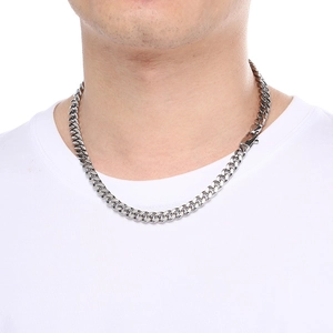 Close-up of an 8mm silver Cuban link chain necklace worn by a model on plain background