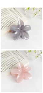 Detailed macro view of plumeria hair claw clips in pastel pink and purple colors