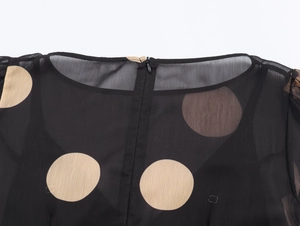 Détail de l'encolure dos d'une robe en mousseline noire à pois avec fermeture invisible