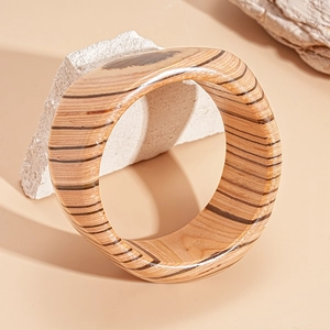Detailed macro view of retro wooden bangle with natural dark brown grain and smooth edges