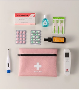 Pink portable first aid kit with infrared thermometer, bandages, and medicine supplies