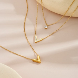 Three-piece layered gold titanium steel necklace set featuring V-pendant and zircon stone