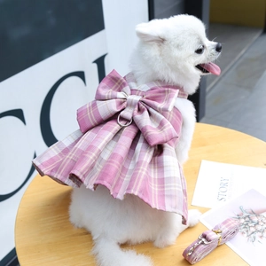 Pink plaid dog harness dress with large bow and matching leash on a Pomeranian