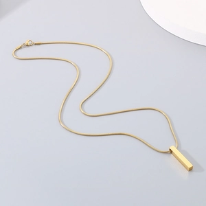 Detailed view of a polished gold rectangular bar pendant on a sleek snake chain necklace