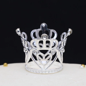 Detail of a silver mini crown with rhinestones for cake decor and party hairstyles