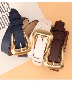 Detailed view of three rolled faux leather belts with golden triangular buckles