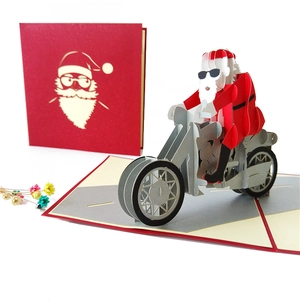3D pop-up Christmas card featuring Santa Claus riding a motorcycle on red background