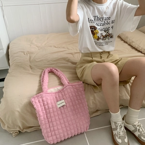 Vista dettagliata della borsa tote trapuntata rosa con trama a nuvola e logo