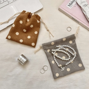 Close-up of corduroy drawstring pouches with polka dot pattern for cosmetic storage