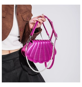 Details zur magentafarbenen Muscheltasche mit Perlenkette und glänzendem Finish