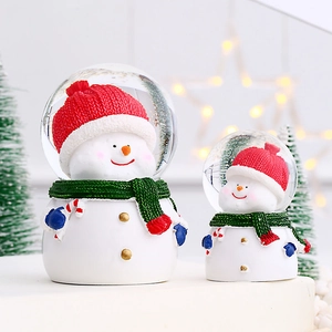 Macro detail of snowman crystal balls with resin base and festive knitted hats