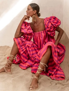 Detail of puffed sleeves and vibrant orange stripes on bohemian vacation maxi dress