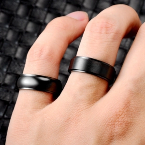 Close-up of polished and matte black titanium steel spinning rings on fingers for meditation