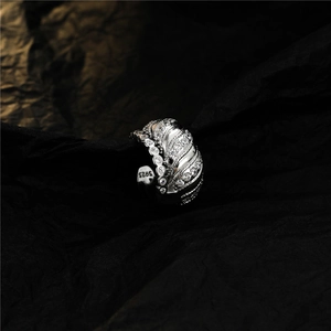 Silver S925 sterling silver ring with white zircon stones on a dark textured background