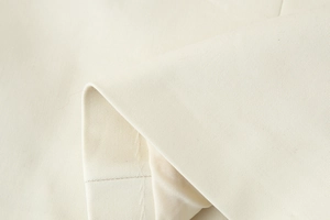 Detailed macro view of beige twill fabric texture and stitching on square neck vest
