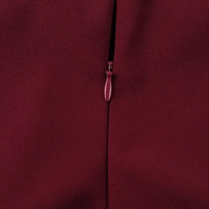 Close-up of invisible zipper and woven fabric texture on a wine red elegant A-line dress