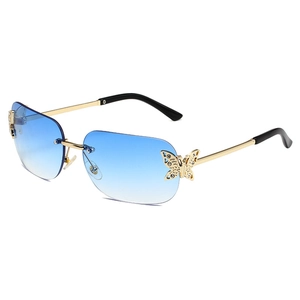 Rimless butterfly sunglasses with blue gradient lenses and rhinestone-encrusted gold wings