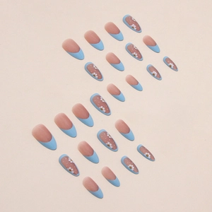Faux ongles amande mats avec pointes French bleues et motifs floraux de marguerites