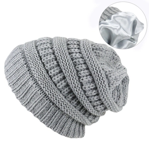 Close-up of the double-layer knitted beanie showing smooth grey satin lining and texture